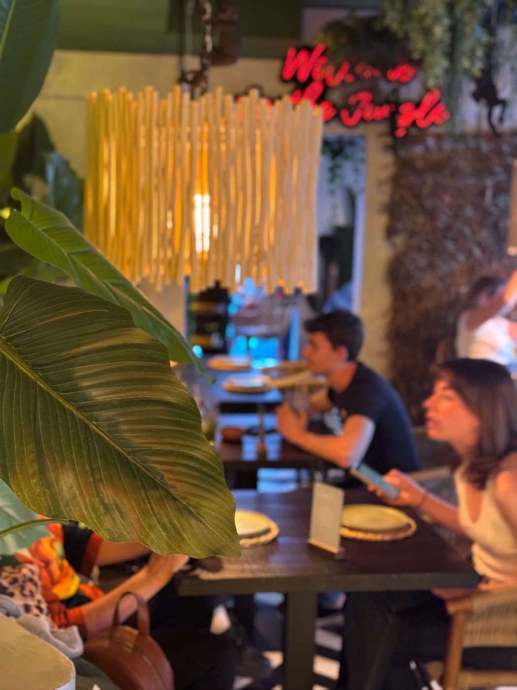 "Welcome to the Jungle" neon sign over the dining room